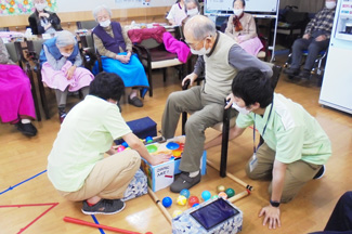 時間内にどれだけボールを箱に仕舞えるか、観客が見守る中で挑戦中